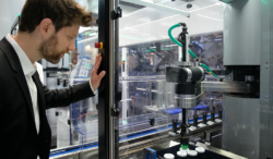 A man observes part of a packaging machine.
