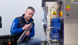 A service technician modernizes an industrial product inspection system as part of a retrofit project.