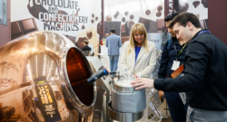 People standing next to a processing machine.