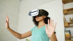 Person wearing a virtual reality headset interacts with a virtual environment using hand movements.